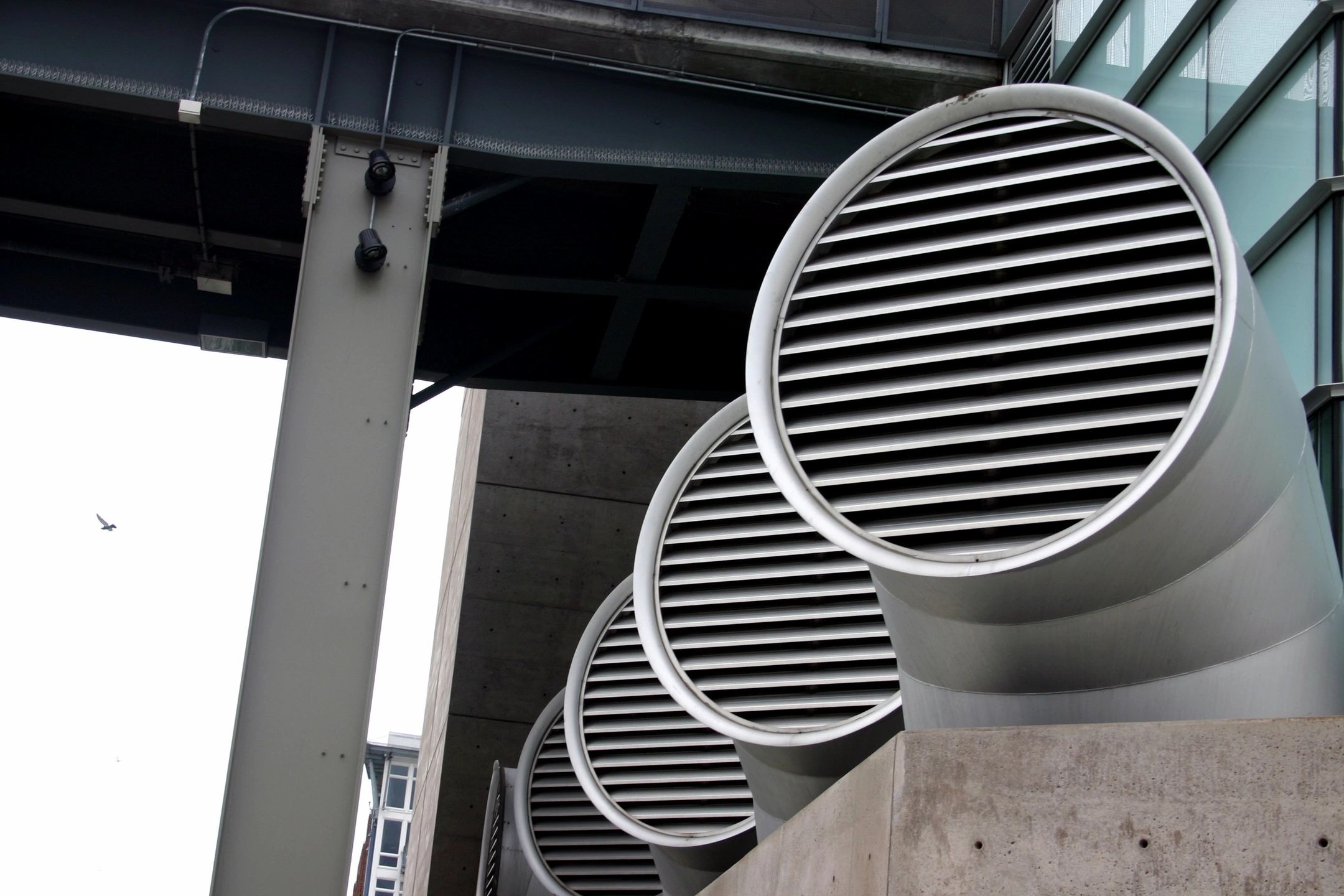 A bunch of vents are on the side of a building