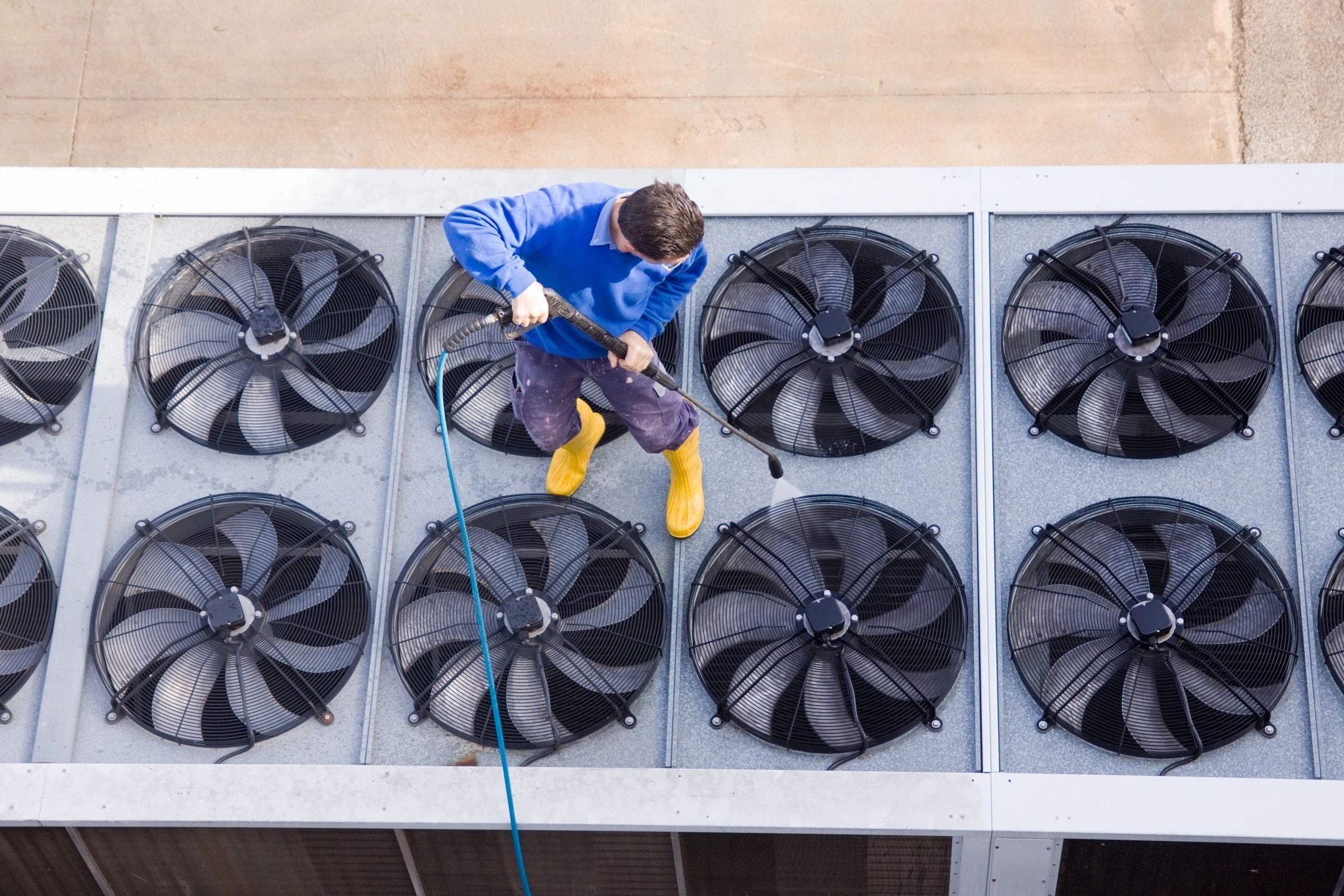 A man is cleaning the air conditioning units.