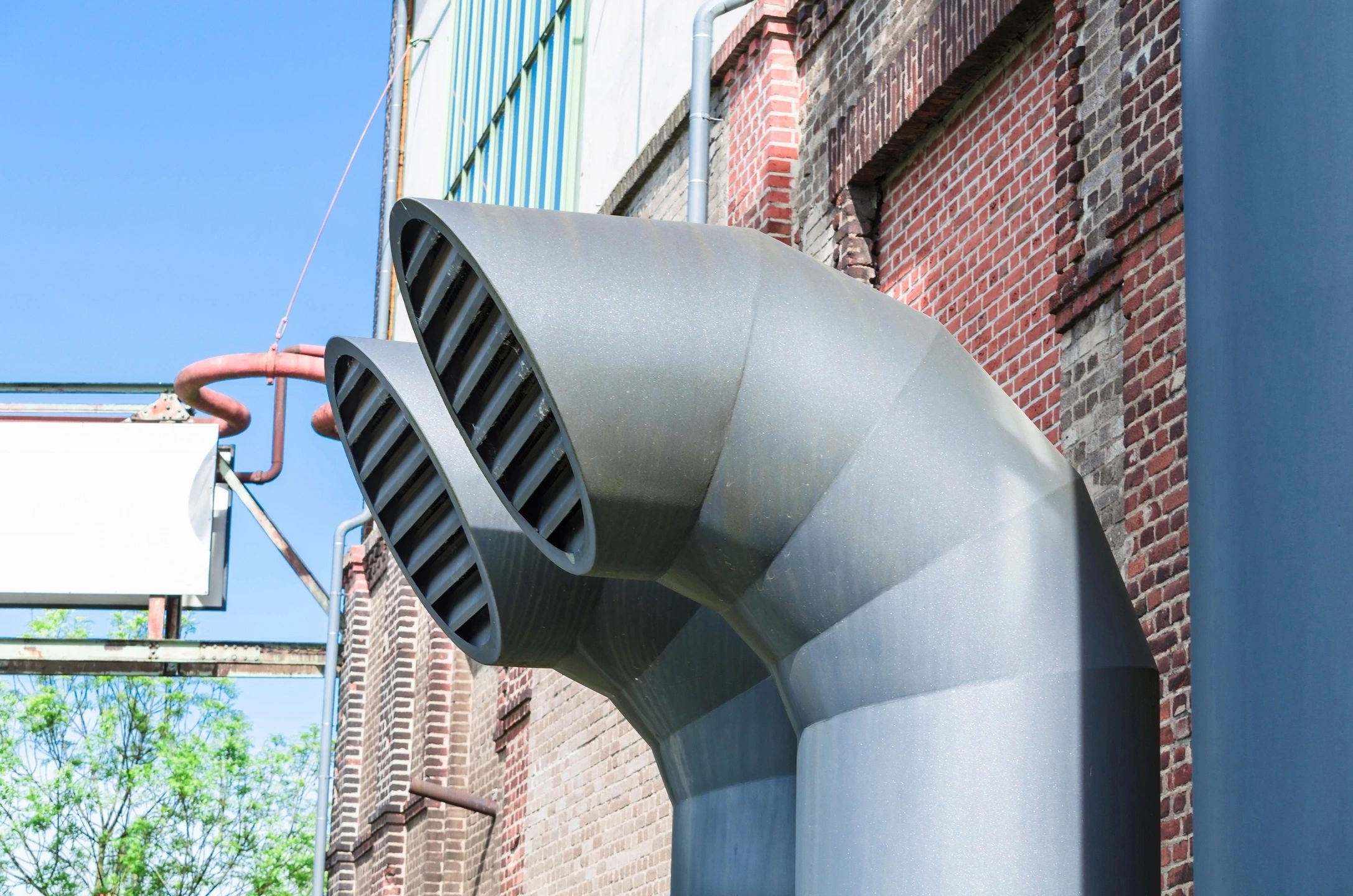 A metal pipe sitting in front of a building.