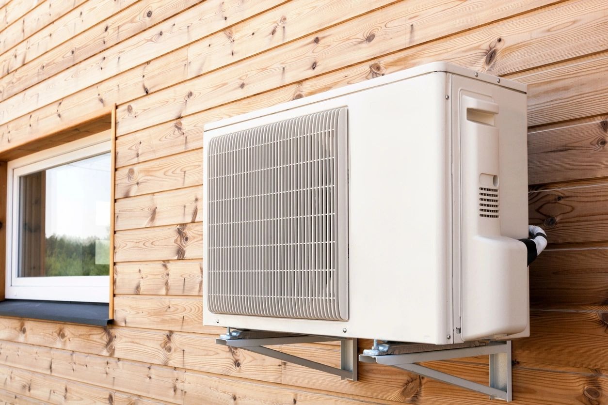 A white air conditioner mounted on the side of a building.