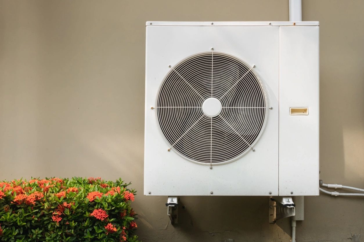 A white air conditioner mounted on the side of a wall.