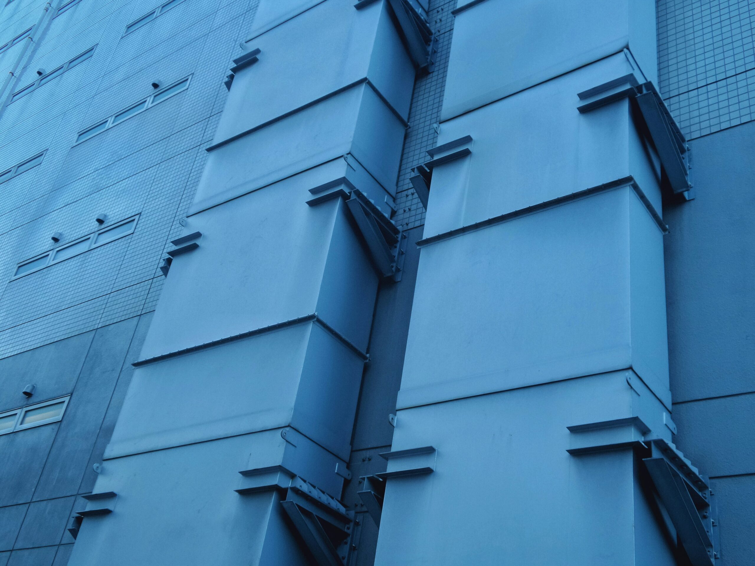 A blue building with many windows and some lines